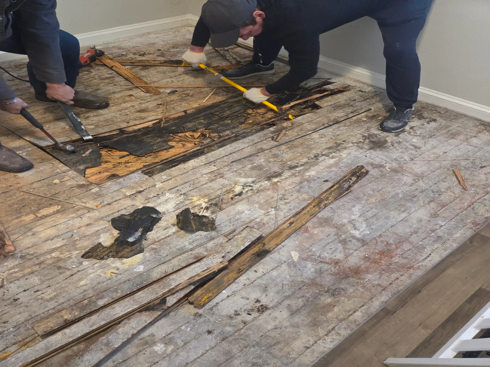 A rotted wood subfloor being torn out before a Firmhand floor replacement